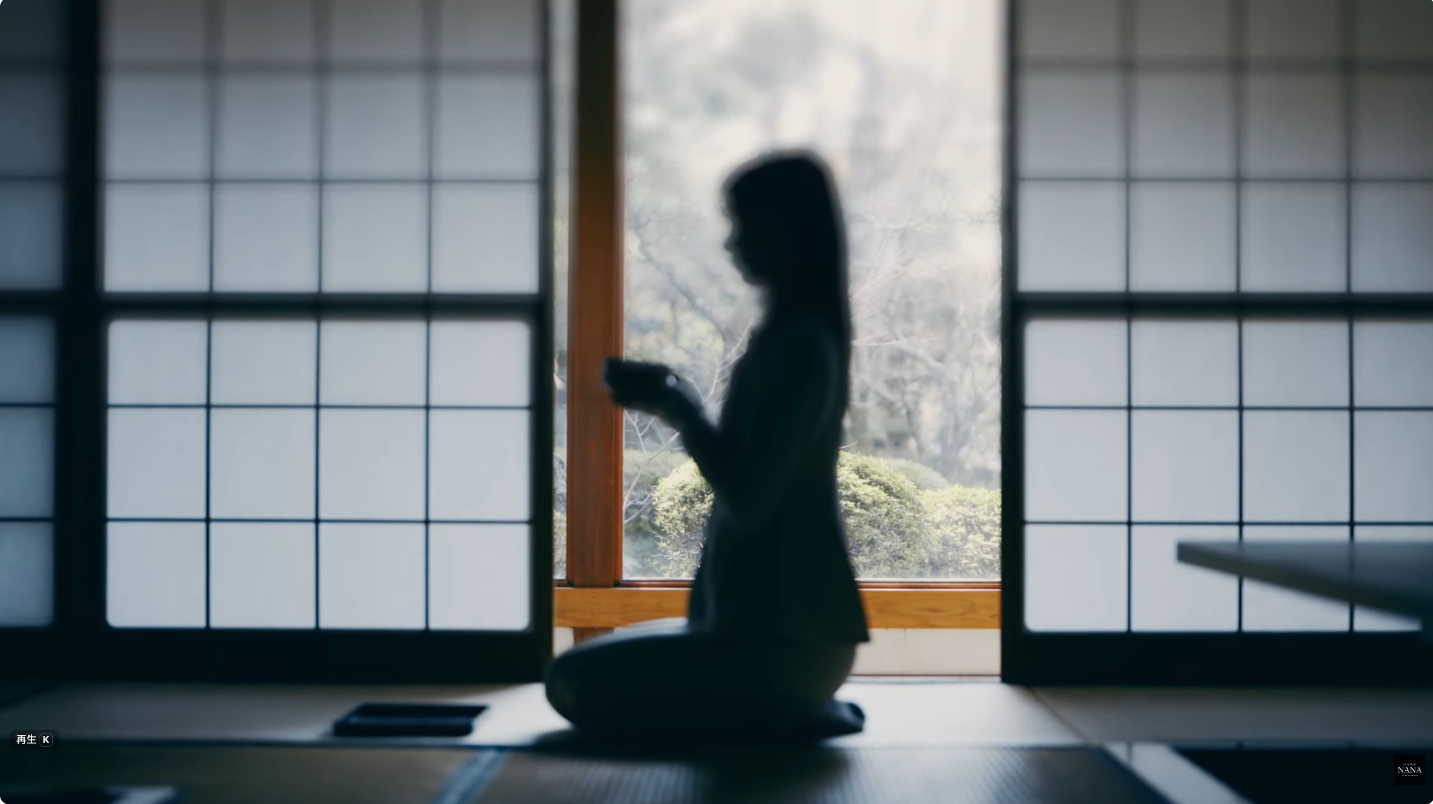 和室の障子前で正座し、茶碗を持つ人物のシルエット