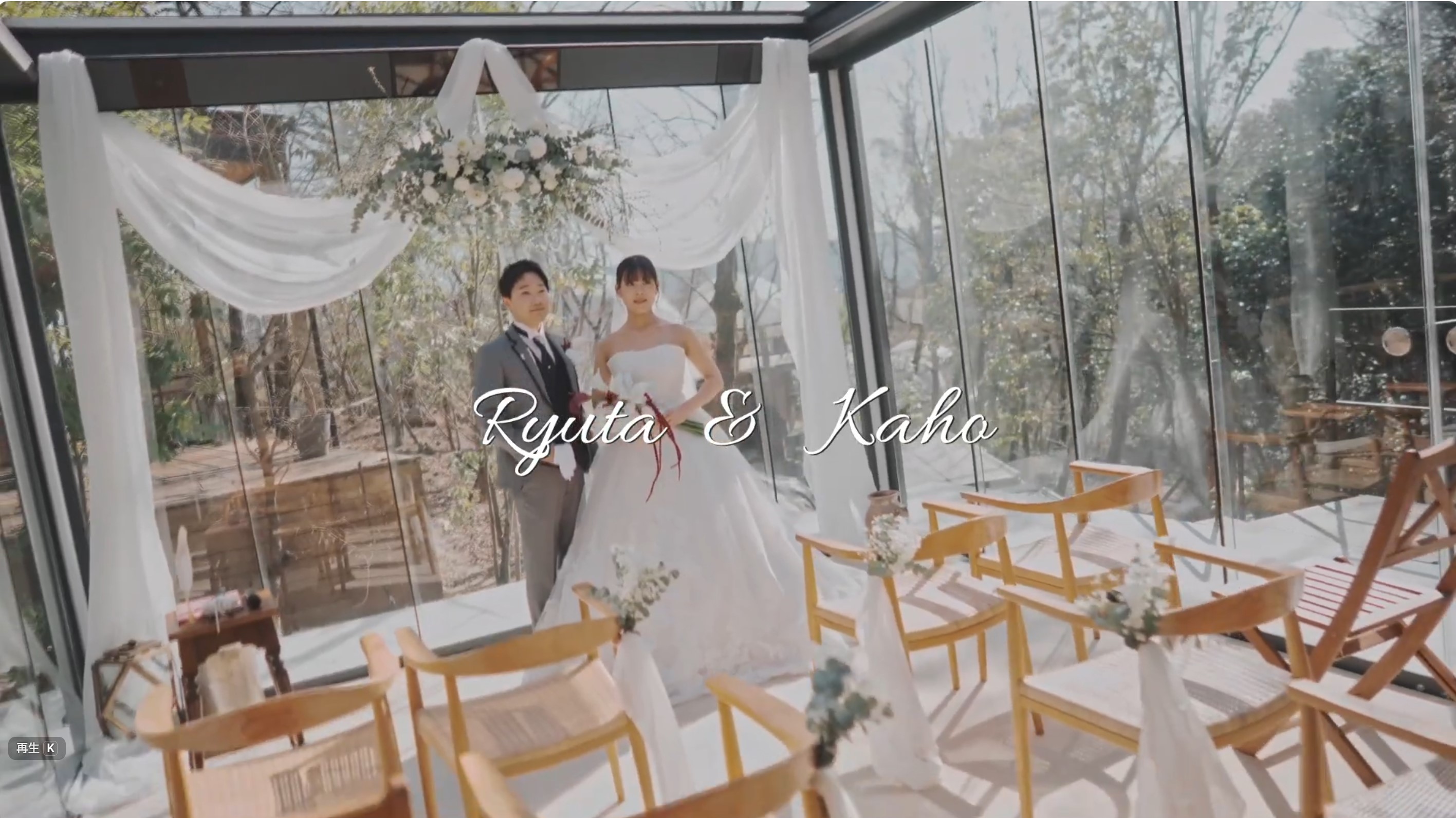 ガラス張りのチャペルで白ドレスとスーツ姿のカップルが並ぶ結婚式の一場面